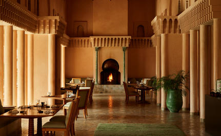 安缦珍纳度假村的Nama餐厅，灯火通明的摩洛哥建筑走廊，两侧摆放座椅。