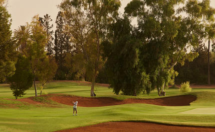 Golf course at Amanjena resort in Morocco, with manicured fairways and mature trees.