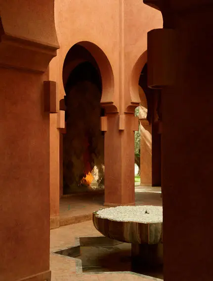 Lobby with bassin at Amanjena resort, Morocco, terracotta arches and warm lighting.