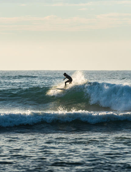 Surfer riding a wave at Amanwella's surfing beach in Sri Lanka.