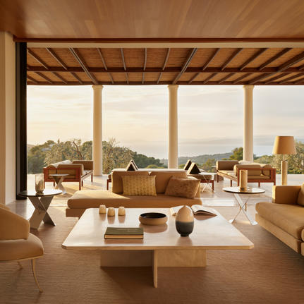 Villa living area at Amanzoe with wooden beams, terracotta furnishings, and Aegean views.