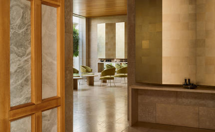 Spa interior lounge at Amanzoe resort with warm wooden tones and marble accents.