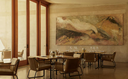 Amangiri restaurant area with warm earth tones, wooden screens, and desert landscape artwork.