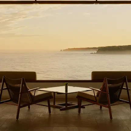 Two wooden chairs facing the sea at sunrise, Amanera resort, Dominican Republic.