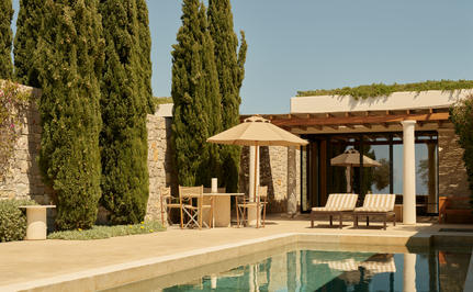 Amanzoe beach club cabana with swimming pool, stone terrace and cypress trees.