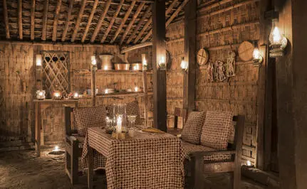 Ruang makan intim di Amanjiwo dengan pencahayaan lantern dan dekorasi rotan alami.