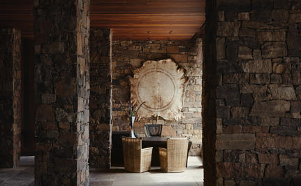 Amangani lobby entrance with stone archway and wooden ceiling details.