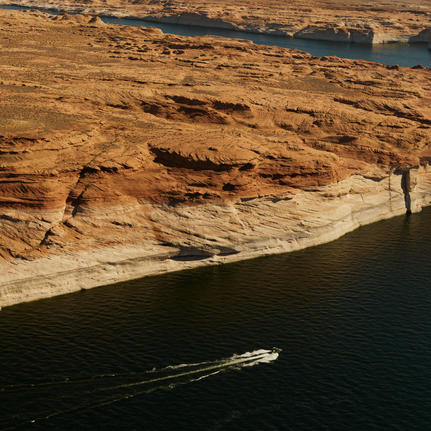 Aerial view of a boat navigating the waters of Lake Powell near Amangiri.