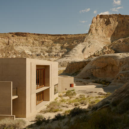 Amangiri nestled into a desert cliff face, with minimalist architecture and natural stone surroundings.