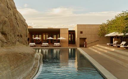 Main pool at Amangiri with terracotta architecture and desert landscape at sunset.