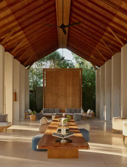 Pavillon d'arrivée à Amanyara, avec plafond en bois et bancs en pierre encadrant un autel central.