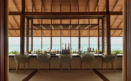 Beach Club at Amanyara resort with wooden framework overlooking turquoise waters.