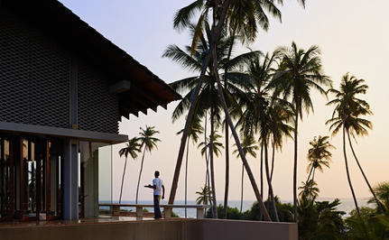 Amanwella exterior with palm trees and coastal architecture at dusk, Sri Lanka.