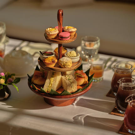 Afternoon tea tiered stand with pastries and cakes in the library at Amantaka, Laos.