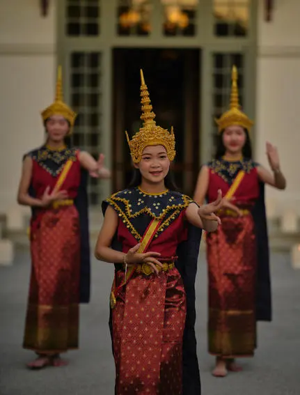 Lao dancers in traditional crimson silk costumes performing at Amantaka's poolside dinner celebration.