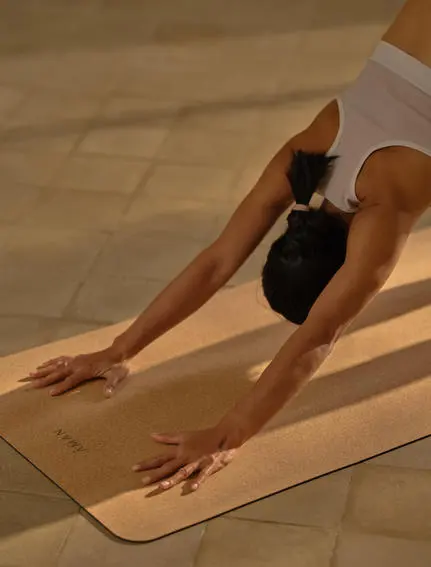Yoga instructor in sunrise movement class on mat at Amantaka, Laos.