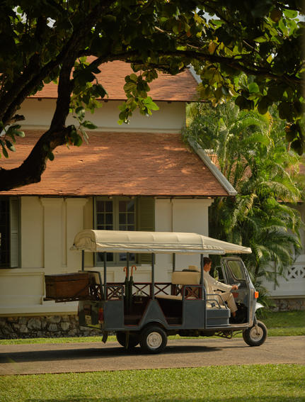 Tuk-tuk parked beneath trees at Amantaka, Laos resort.