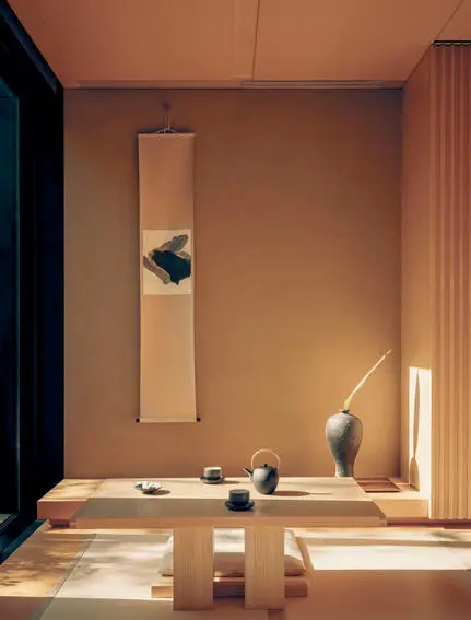 Interior suite at Aman Kyoto resort featuring minimalist wooden furnishings and warm ambient lighting.