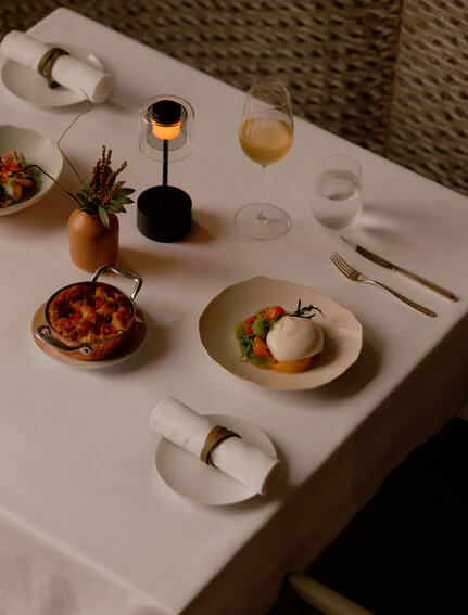 Dining table setting at Aman Nai Lert Bangkok with plated dishes and table appointments.