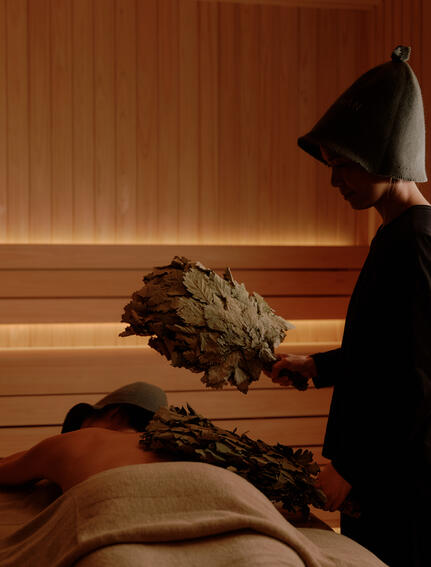 A therapist performs a traditional massage treatment on a guest at Aman Nai Lert Bangkok's spa house.