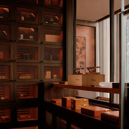 Cigar bar at Aman Nai Lert Bangkok with wooden cabinetry and display cases.