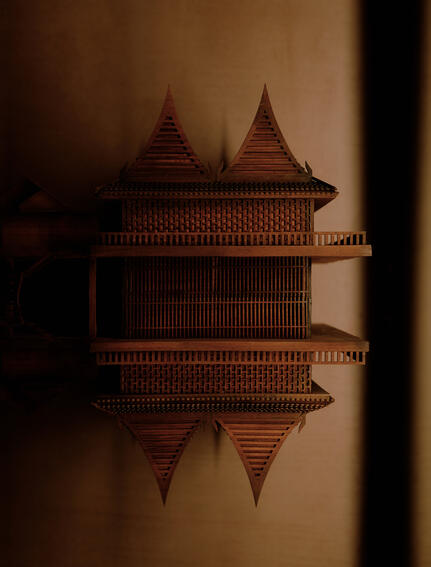 Architectural detail of a traditional Thai-style building at Aman Nai Lert Bangkok, reflected in still water.