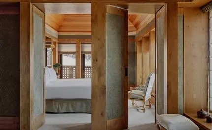 Aman Le Mélézin suite bathroom with wooden cabinetry and stone finishes.