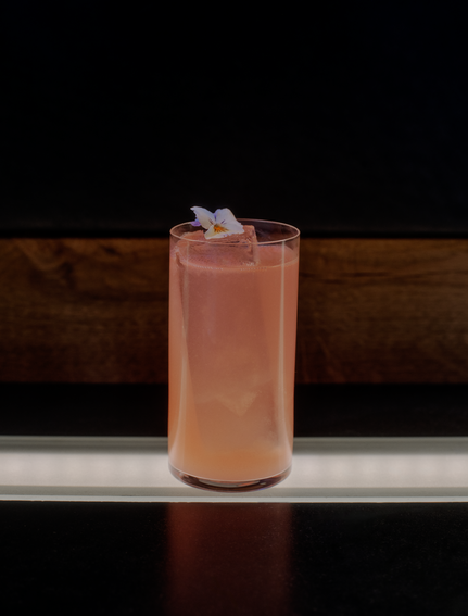 FAMP B cocktail at Aman Le Mélézin, a blush-coloured drink garnished with ice in a tall glass.