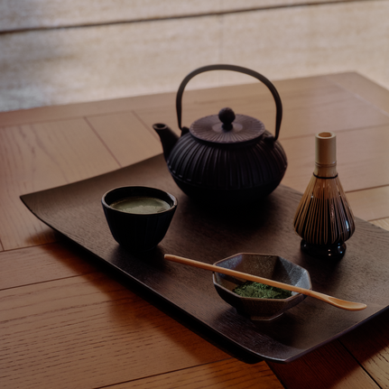 Japanese tea ceremony setup at Aman Le Mélézin with black teapot, cup, and traditional implements on wooden tray.