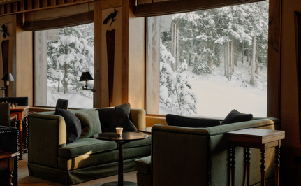 Two leather chairs facing snow-covered windows at Aman Le Mélézin, France.