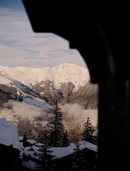 Snowy alpine peaks framed through a window at Aman Le Mélézin, French Alps.