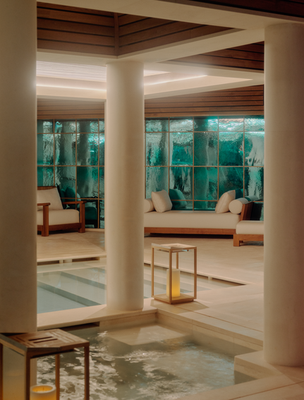 Spa and wellness pool at Aman Le Mélézin viewed through open doorways, with Alpine views beyond.