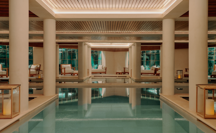 Spa and wellness pool at Aman Le Mélézin, France, with columned architecture and turquoise water.