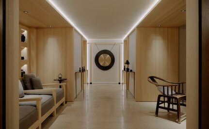 Spa wellness corridor at Aman Le Mélézin with soft lighting, neutral tones, and minimalist décor.