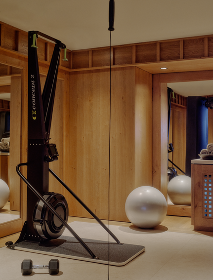 Wellness gym at Aman Le Mélézin with exercise equipment and neutral décor.