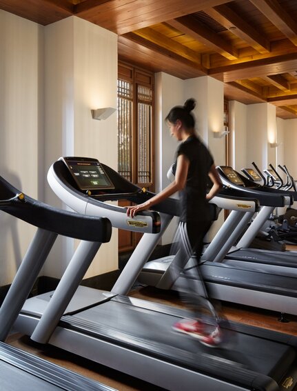 大研安缦度假村健身房内，一位女性在跑步机上运动。