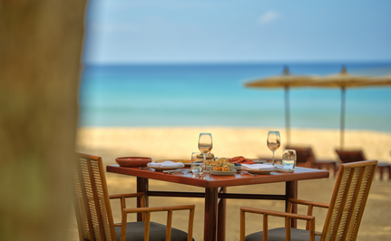 Dining table set for two with beach and sea view at Amanpuri, Thailand.