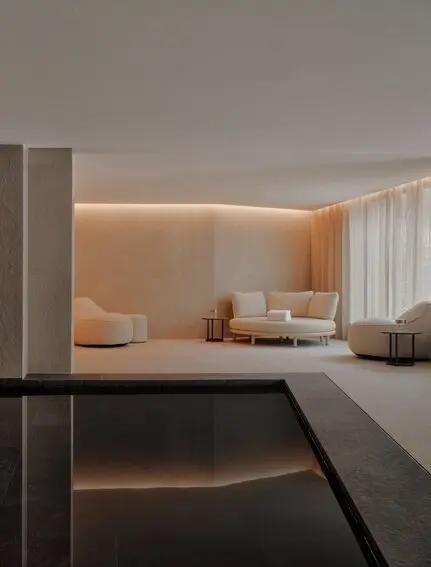 Piscina interna illuminata con vasche in marmo scuro e pareti chiare presso Aman Rosa Alpina.