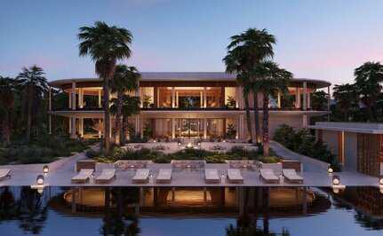 Casa Grande Lodge at Amanvari, Mexico, illuminated at dusk with dining pavilion reflected in still water.