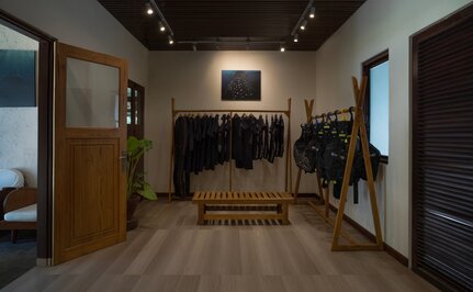 安缦湾澜度假村潜水中心内部，展示木制地板、展示架和潜水设备。