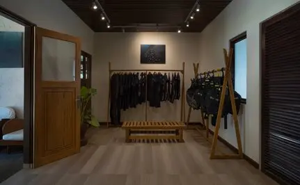 Amanwana dive centre interior with wooden flooring, diving equipment displays, and warm ceiling lighting.