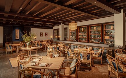 Amanfayun's dining venue with wooden tables and chairs, warm lighting, and traditional architectural details.