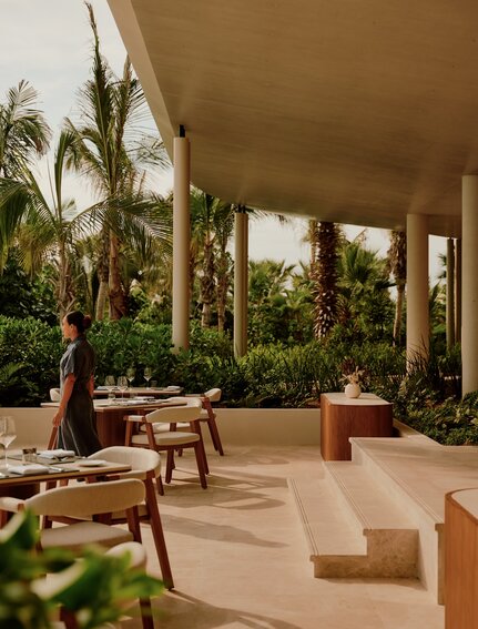 Covered terrace at Amanvari with dining furniture and views towards lush gardens in Mexico.