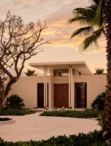 Spa entrance at Amanvari with sculptural pavilion at dusk, framed by desert palms.