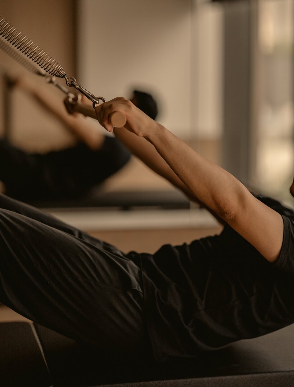 Person performing a suspension exercise at Aman Nai Lert Bangkok's fitness facility.