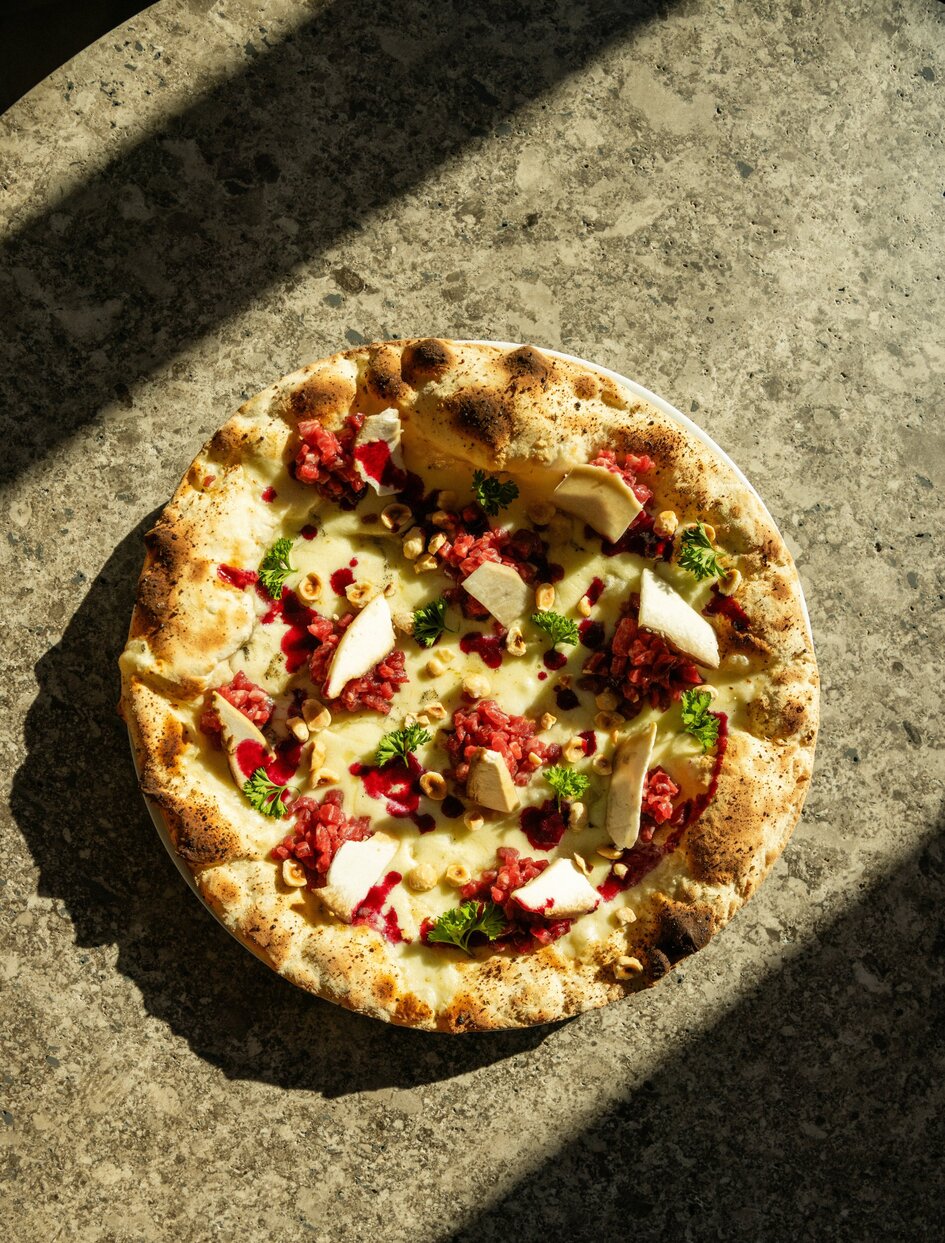 Pizza al forno con pomodori e erbe aromatiche al Grill di Aman Rosa Alpina.
