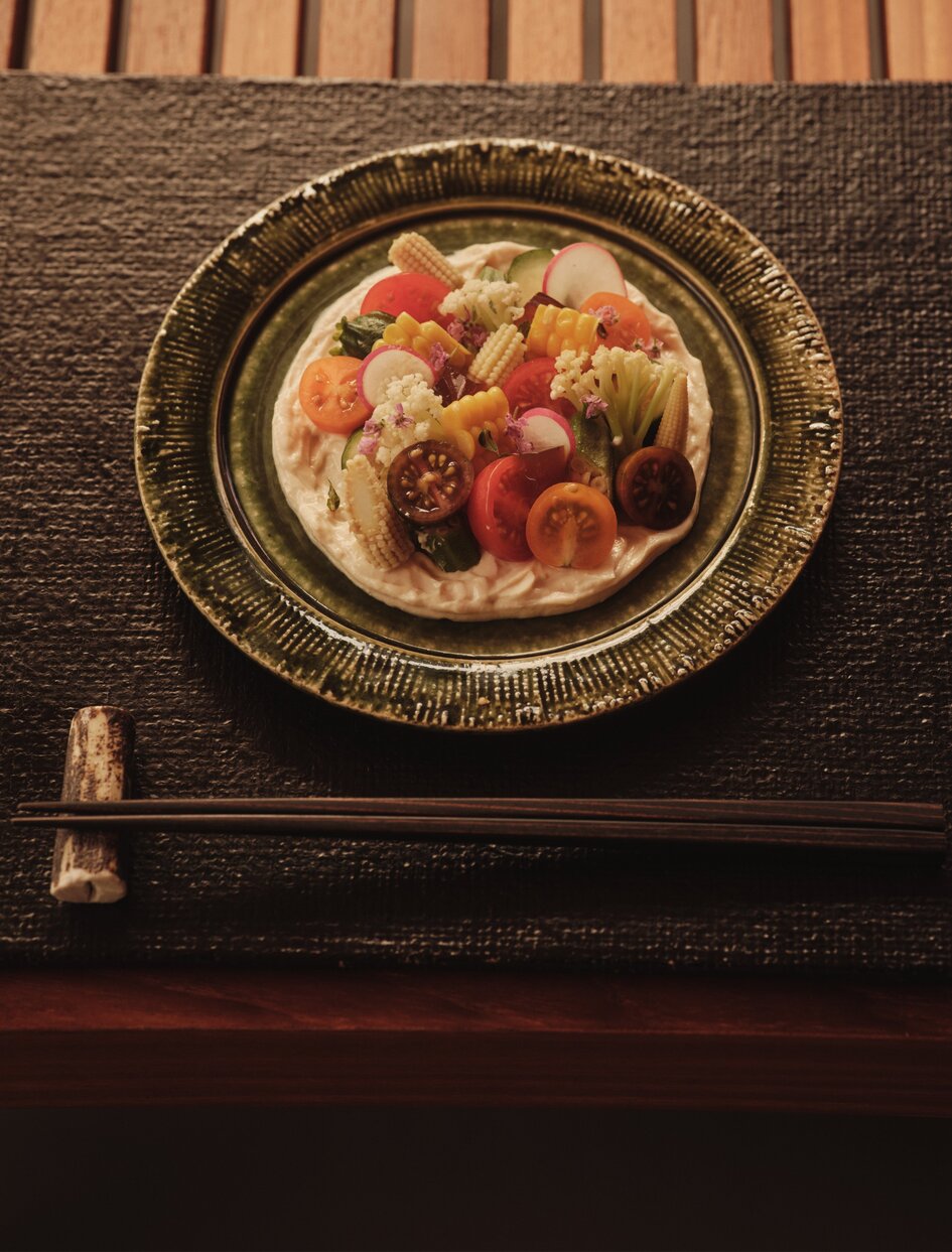 Assiette de fruits frais sur table sombre, terrasse d'Aman New York.