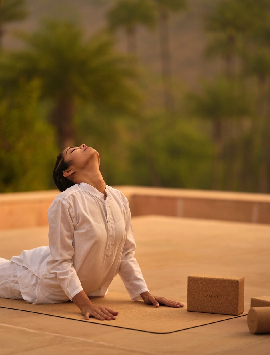 Woman practising yoga on terrace at Amanbagh, India spa and wellness resort.