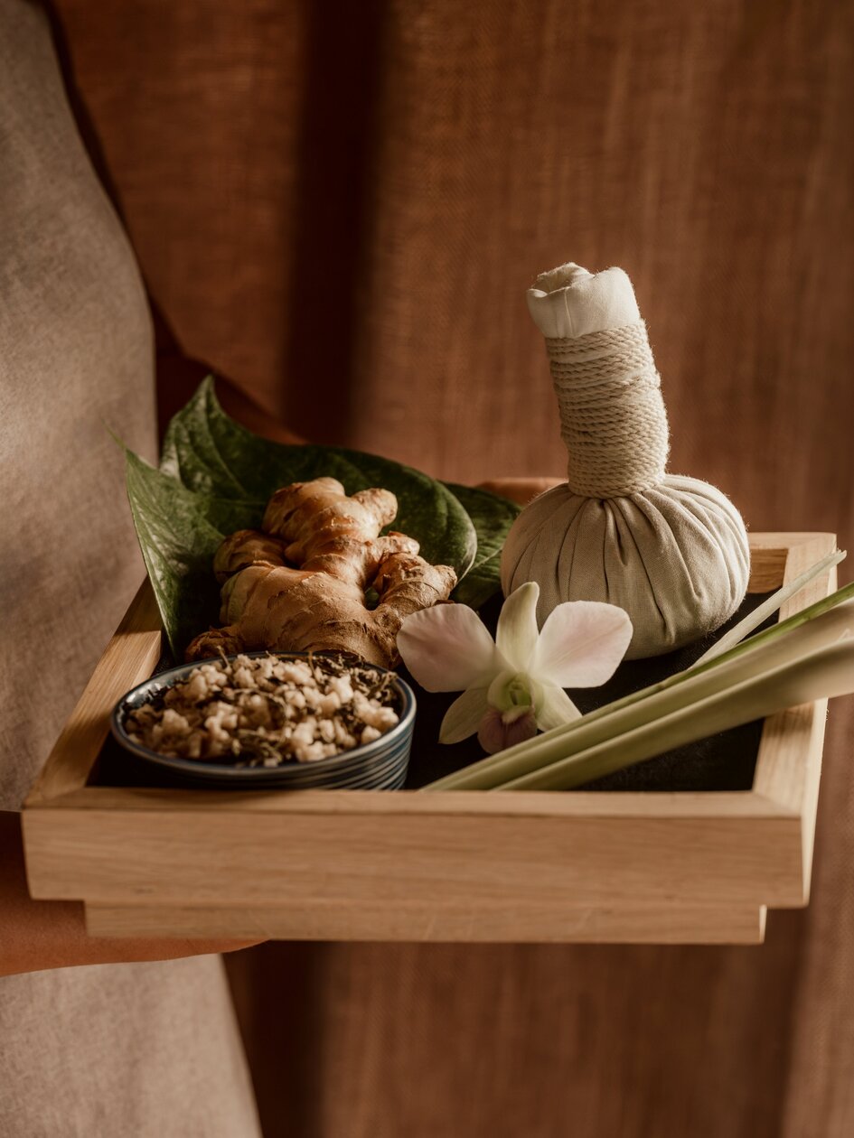 Herbal spa essentials arranged on wooden tray at Amanoi resort, featuring natural ingredients and wellness products.