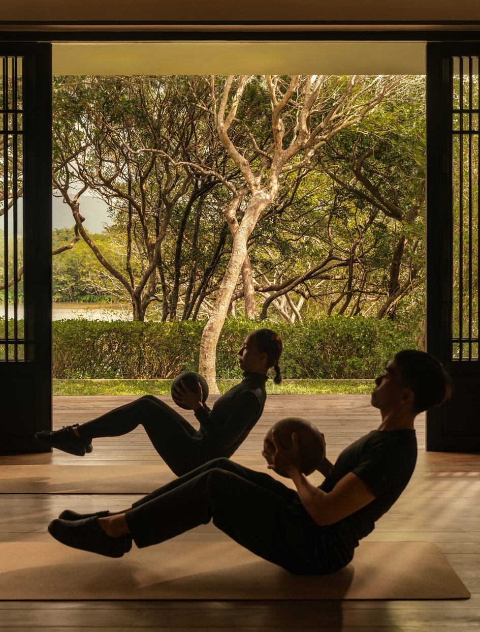 Guest practising yoga in the wellness gym at Amanoi, Vietnam, with garden views.